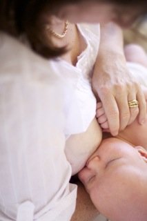 breastfeeding newborn holding mothers hand